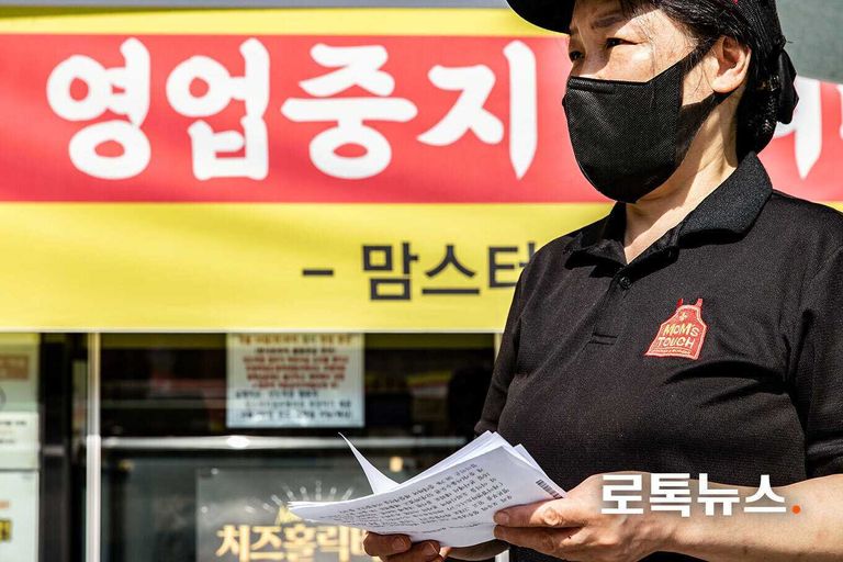 맘스터치 상도역점 직원이 직접 거리로 나와 행인에게 전단지를 건네고 있다. /안세연 기자