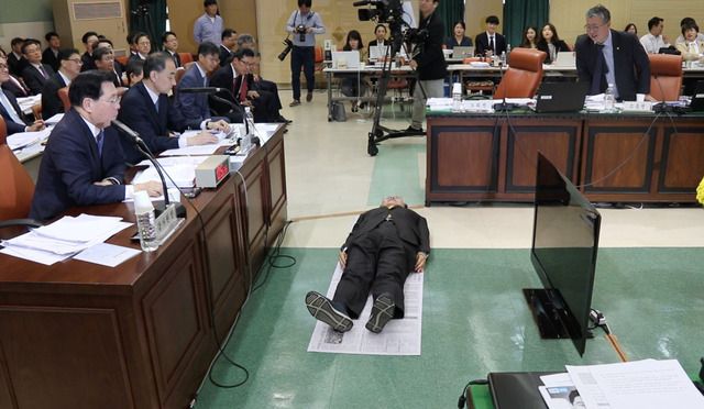 고 노회찬 의원이 재소자 가용면적을 설명하며 신문지를 가져와 직접 누웠다. /노회찬 의원실 제공