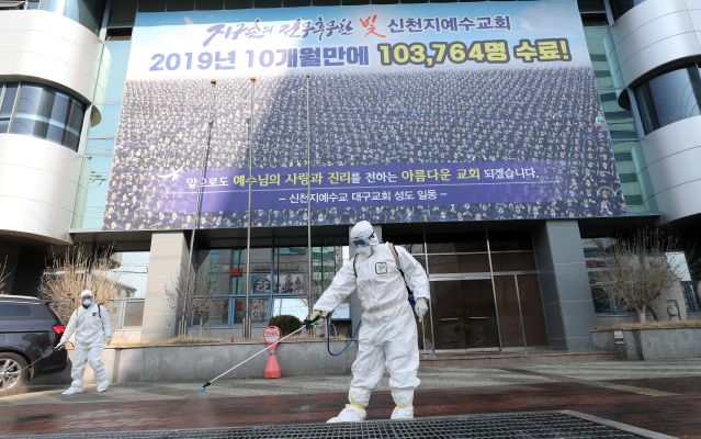지난 20일 방역 당국자들이 신천지 대구교회 앞을 방역하고 있다. 이들은 교회 내부를 방역하지 못해 건물 주변부만 매일 방역하고 있다. /연합뉴스