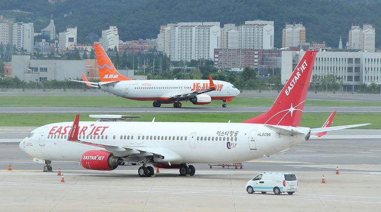 제주항공이 이스타항공과의 노딜을 선언한 다음 날인 24일 서울 김포공항 주기장에 세워진 이스타항공 여객기 뒤로 제주항공 여객기가 이륙하고 있다. /연합뉴스